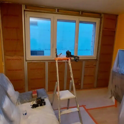 Chambre en rénovation avec échelle et fenêtre isolée