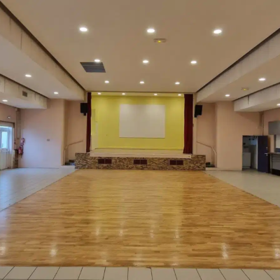 Salle des fêtes avec scène et piste en bois