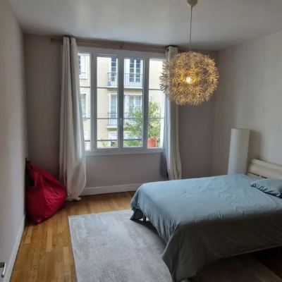Chambre lumineuse avec lit double et grande fenêtre