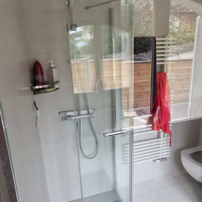 Douche moderne vitrée avec pommeau pluie et carrelage beige