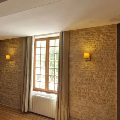 Chambre rustique avec mur en pierre et fenêtre