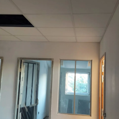 Couloir en rénovation avec plafond suspendu et portes