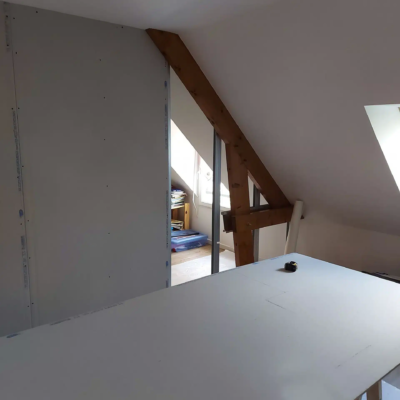 Aménagement de combles avec cloison et poutre apparente